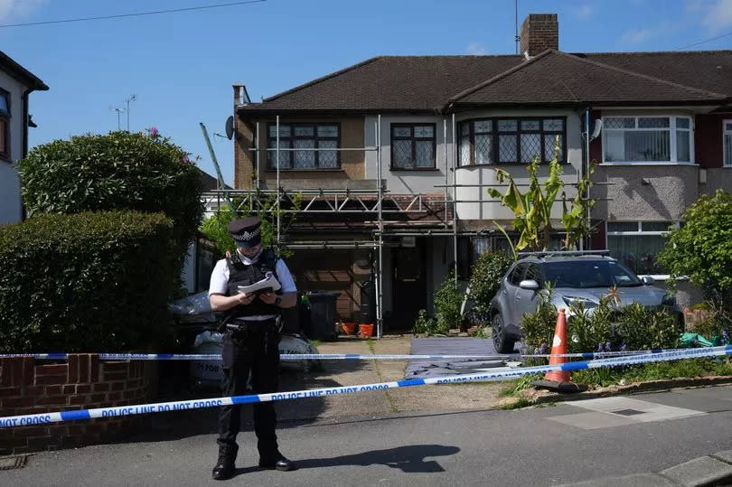 A police officer guards a cordon outside a house