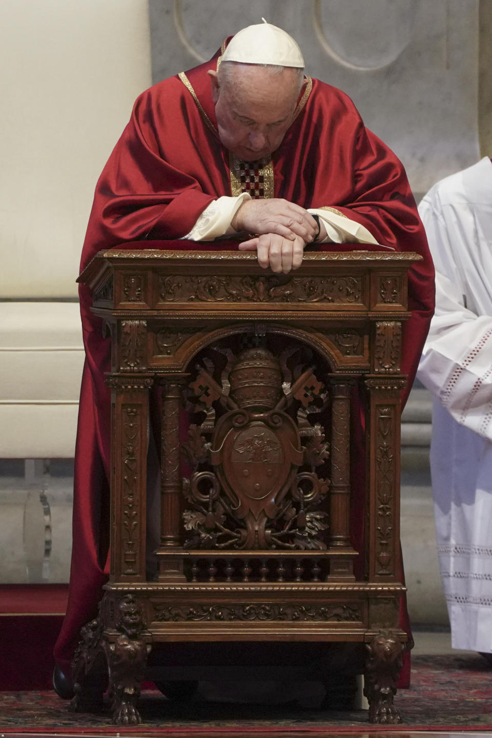 Pope Francis kneels during a Mass for the Passion of Christ, at St. Peter's Basilica, at the Vatican, Friday, April 10, 2020. The new coronavirus causes mild or moderate symptoms for most people, but for some, especially older adults and people with existing health problems, it can cause more severe illness or death. (AP Photo/Andrew Medichini, Pool)