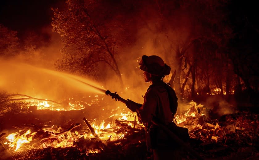 Firefighter Ron Burias battles the Fawn Fire as it spreads north of Redding, Calif. in Shasta County