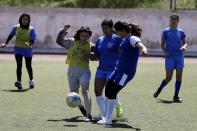 In this Thursday, May 2, 2019 photo, members of Hestia FC Women's Refugee Soccer and AO Vrilission players fight for the ball during a friendly game in Athens. Many of the players at Hestia FC weren't allowed to play or even watch soccer matches in their home countries. Hestia FC was set up by the Olympic Truce Centre, a non-government organization created in 2000 by the International Olympic Committee and Greek Foreign Ministry. (AP Photo/Thanassis Stavrakis)