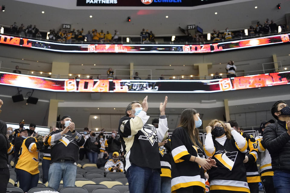 Pittsburgh Penguins fans celebrate the second goal of the period by Pittsburgh Penguins' Kasperi Kapanen (42) against the Philadelphia Flyers during the second period of an NHL hockey game, Tuesday, March 2, 2021, in Pittsburgh. It was the first game a limited number of fans were allowed to attend in Pittsburgh after some COVID 19 crowd restrictions were lifted buy the state earlier this week. (AP Photo/Keith Srakocic)