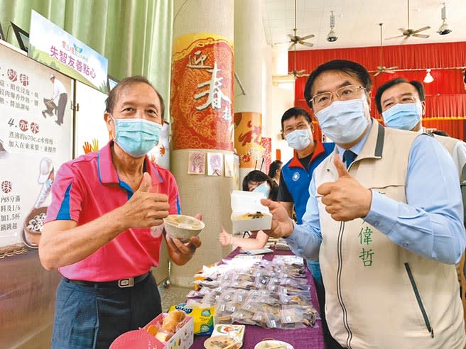 今年71歲的林祈松（左）外號「松哥」，雖罹患失智症卻有好手藝，製作獨門碗粿，連台南市長黃偉哲（右）都讚不絕口。（李宜杰攝）