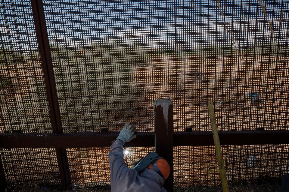A welder fixes part of the border wall that had been breached west of the Santa Teresa Port of Entry in New Mexico in late August 2023.