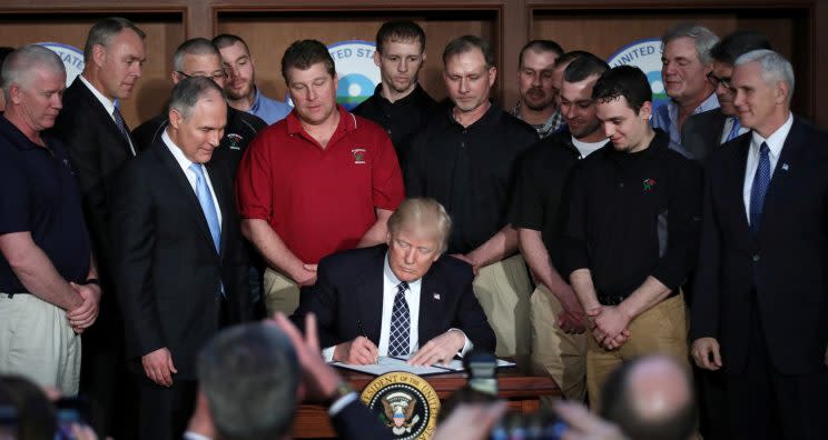 President Donald Trump signs an executive order eliminating Obama-era climate change regulations at the Environmental Protection Agency in Washington on March 28, 2017. (Photo: Carlos Barria/Reuters)