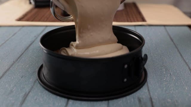 Pouring cheesecake batter into cake tin