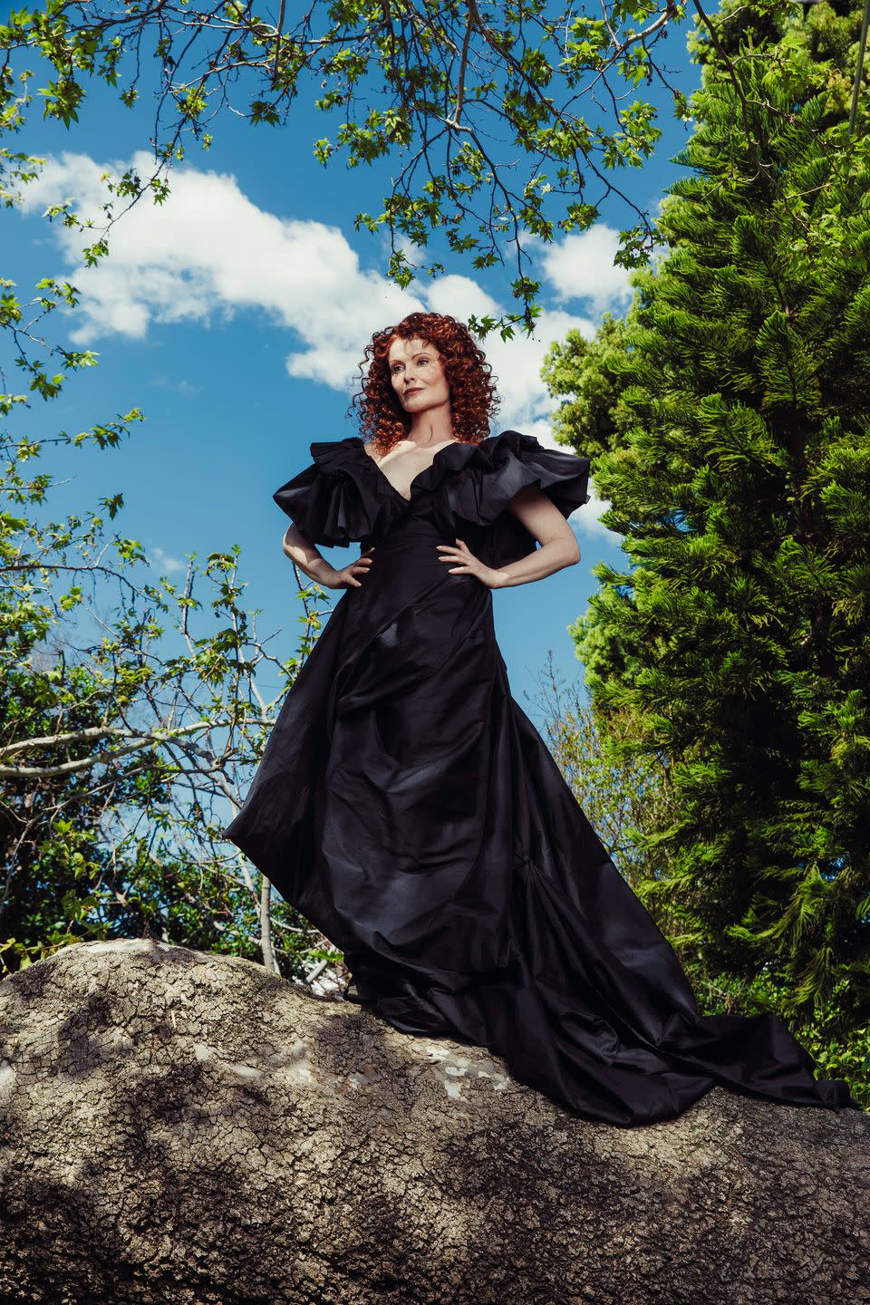 rebecca wisocky, who plays hetty on cbs's ghosts, poses in black gown outdoors in natural setting