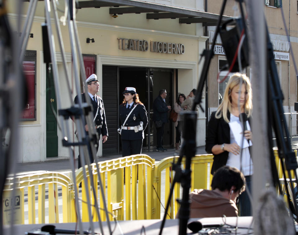 Journalists assemble their equipment in front of the Teatro Moderno theater where the first hearing of the trial for the Jan. 13, 2012 tragedy, where 32 people died after the luxury cruise Costa Concordia was forced to evacuate some 4,200 passengers after it hit a rock while passing too close to the Giglio Island, is taking place in Grosseto Monday Oct. 15, 2012. (AP Photo/Gregorio Borgia)