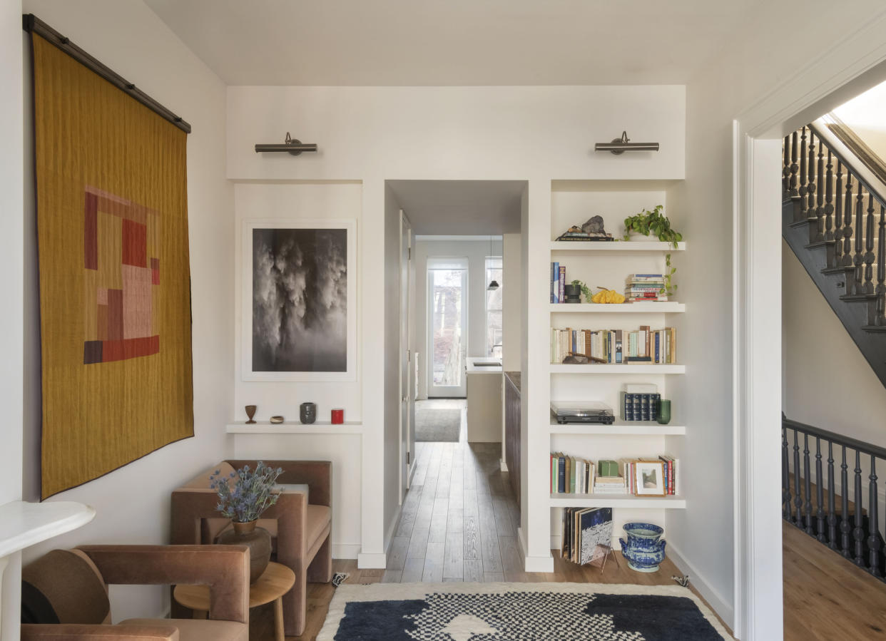  Living room with white walls and bookcase around door frame. 