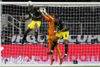 Jamaica forward Cory Burke (9) and defender Liam Moore (6) help goalkeeper Andre Blake (1) against a shot by the United States in the first half of a CONCACAF Gold Cup quarterfinals soccer match, Sunday, July 25, 2021, in Arlington, Texas. (AP Photo/Brandon Wade)