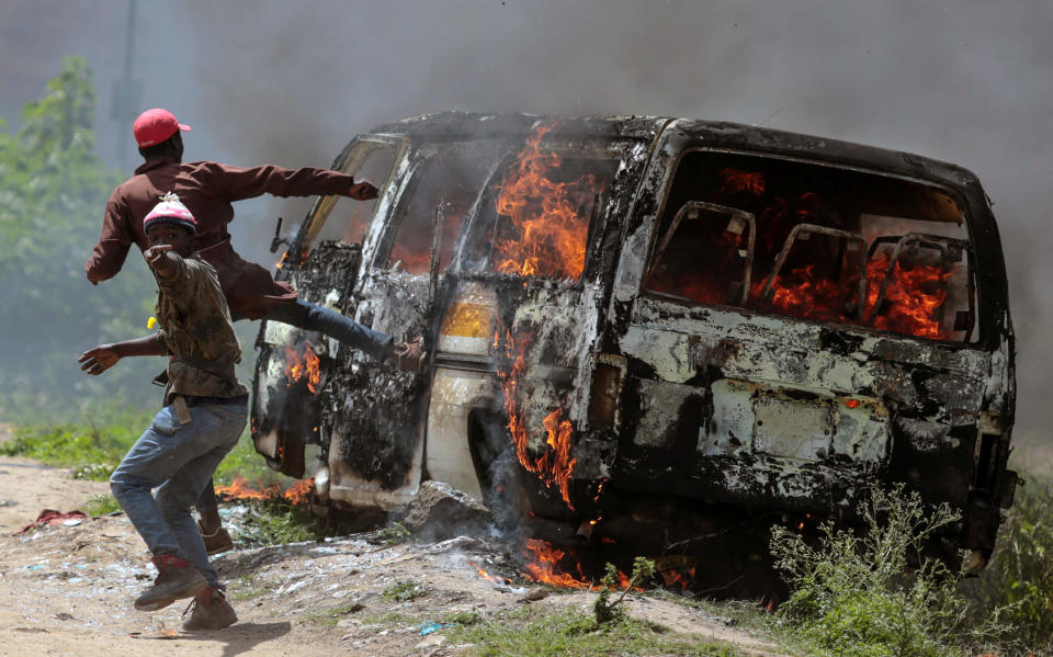 <p>Supporters of Kenyan opposition National Super Alliance (NASA) gesture near a burning vehicle in Embakasi, on the outskirts of Nairobi, Kenya, Nov. 28, 2017. (Photo: Stringer/Reuters) </p>