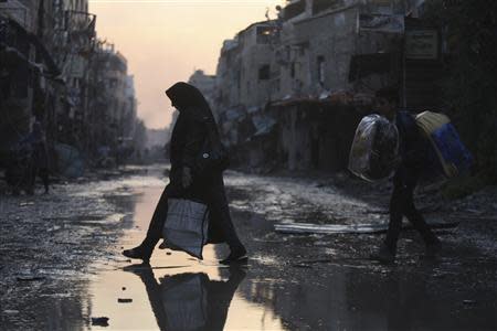 A woman walks along a deserted street after soldiers loyal to Syria's President Bashar al-Assad took control of Hujaira town from rebel fighters, in the town south of Damascus November 21, 2013. REUTERS/Alaa Al-Marjani