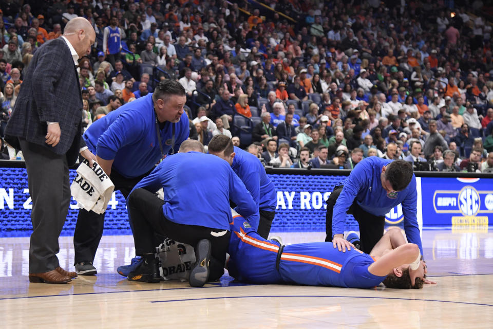 Trainers attend to Florida Gators center Micah Handlogten after an apparent leg injury in the first half against the Auburn Tigers.