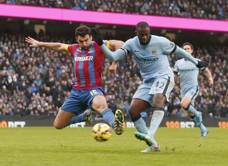 Manchester City's Yaya Toure (R) shoots past Crystal Palace's Mile Jedinak to score a goal during their English Premier League soccer match at the Etihad Stadium in Manchester, northern England December 20, 2014. REUTERS/Phil Noble