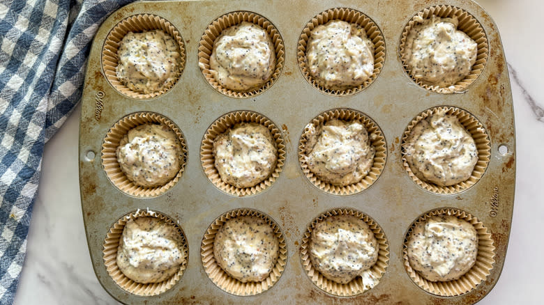 muffin tin with unbaked poppy seed batter