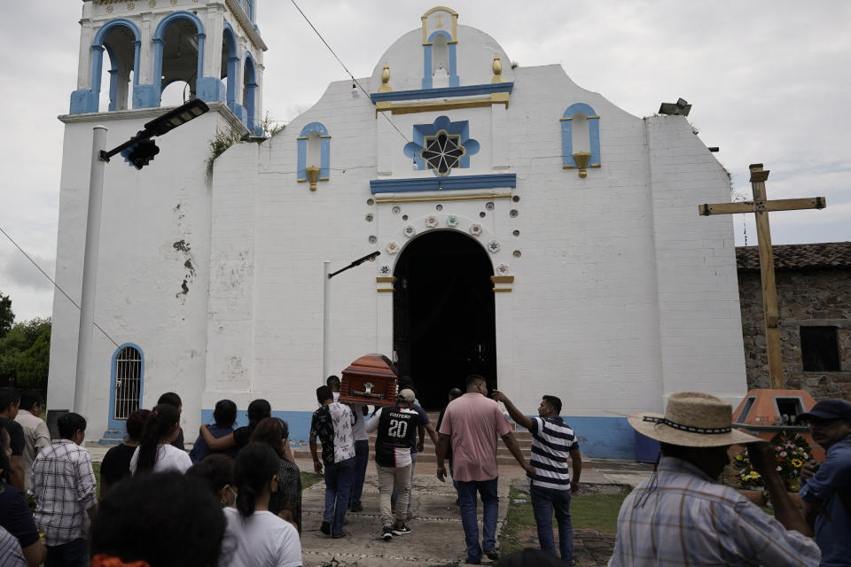 Local residente carry the coffin with the remains of Wilmer Rojas the day after he was killed in a mass shooting in San Miguel Totolapan, Mexico, Thursday, Oct. 6, 2022. Gunmen burst into a town hall meeting and shot to death 20 people, including a mayor and his father, officials said Thursday. (AP Photo/Eduardo Verdugo)