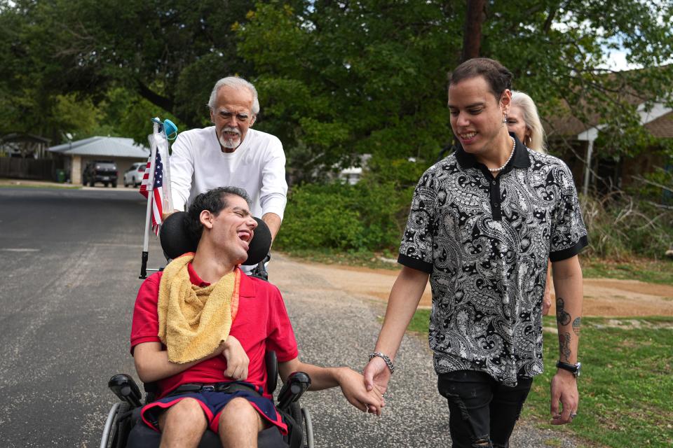 Casey Campos, right, holds his brother Cody's hand while out for a walk.