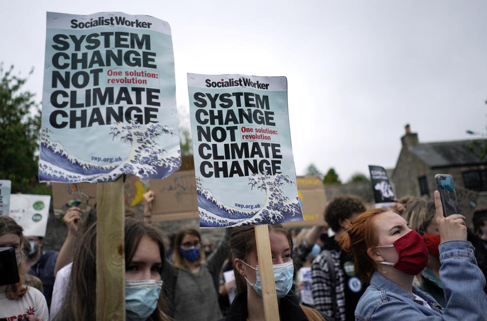 Climate activists wave signs and chant as they march during a demonstration taking place outside a meeting of G7 leaders in Falmouth, Cornwall, England, Friday, June 11, 2021. Leaders of the G7 begin their first of three days of meetings on Friday in Carbis Bay, in which they will discuss COVID-19, climate, foreign policy and the economy. (AP Photo/Alberto Pezzali)