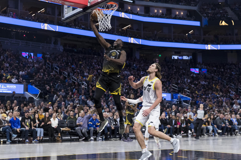 Golden State Warriors forward Draymond Green, center left, lays up the ball in front of Utah Jazz forward Kelly Olynyk (41) during the first half of an NBA basketball game in San Francisco, Friday, Nov. 25, 2022. (AP Photo/John Hefti)