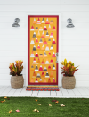 <p>Done properly, a simple candy corn front door design will be the talk of your entire block. You can have the kids pitch in to craft this one!</p><p><strong>Craft the Door: </strong>Create a candy corn-inspired “quilt.” Paint wide stripes, using acrylic paint (we used orange, mustard, cranberry, and gray), on thick artist’s paper. Once dry, cut into equal-size triangles. Cut a 2-inch paper trim in a corresponding color. Attach to door using double- sided tape. </p>