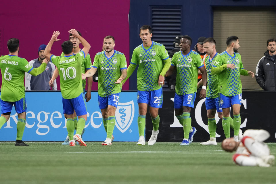 Seattle Sounders forward Jordan Morris (13) celebrates after scoring against FC Dallas with teammates, including midfielder Nicolás Lodeiro (10) and defender Jackson Ragen (25), during the second half of an MLS playoff soccer match Monday, Oct. 30, 2023, in Seattle. (AP Photo/Lindsey Wasson)