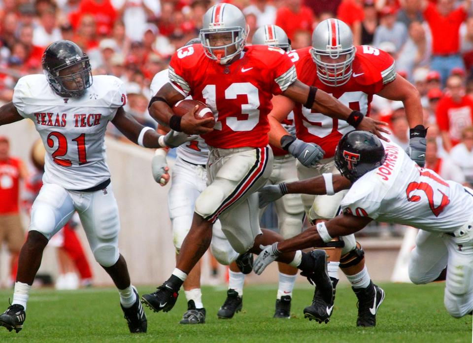 Ohio State freshman tailback Maurice Clarett (13) breaks away from Texas Tech defenders Ricky Sailor (21) and B. Johnson (20) on a touchdown pass reception during the first quarter at Ohio Stadium Saturday, Aug. 24, 2002, in Columbus, Ohio. (AP Photo/Terry Gilliam)