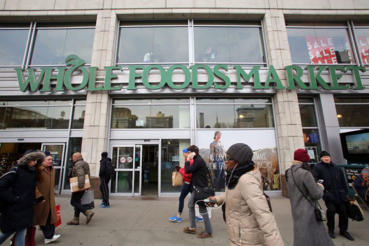 Varias personas pasan frente a las puertas de un local de Whole Foods. (Yahoo)