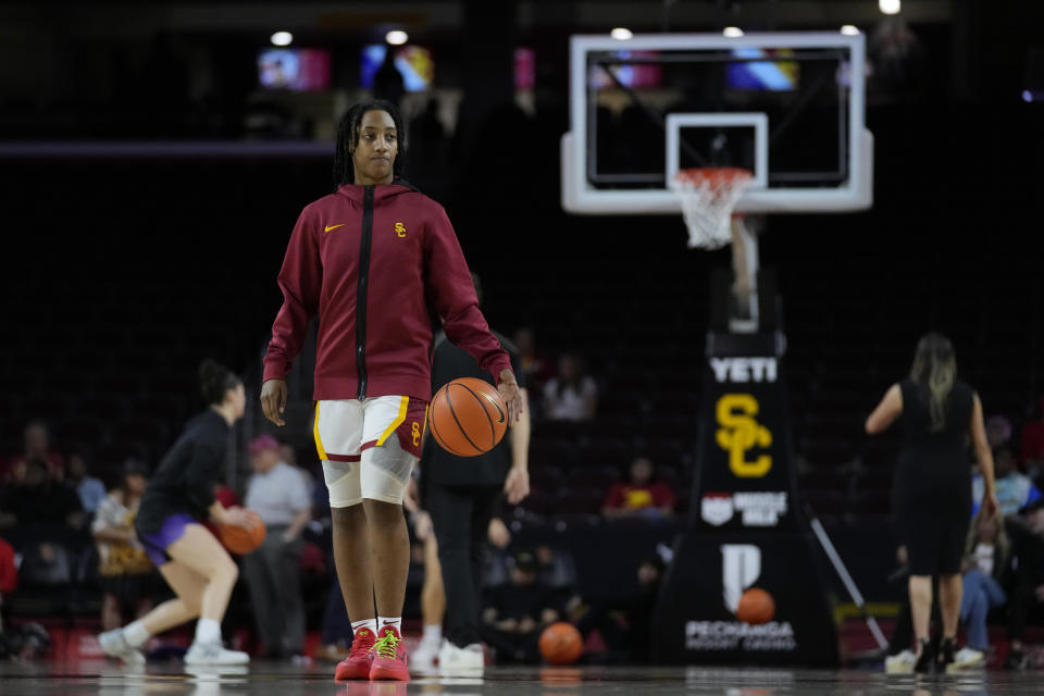 Southern California guard Aaliyah Gayles walks on the court before the team's NCAA college basketball game against Washington in Los Angeles, Sunday, Jan. 28, 2024. Gayles is helping revive Southern California's women's basketball program even though she's played sparingly this season. The reserve guard hounds her teammates as a member of the scout team in practice two years after Gayles was shot numerous times at a house party in her hometown of Las Vegas. (AP Photo/Ashley Landis)