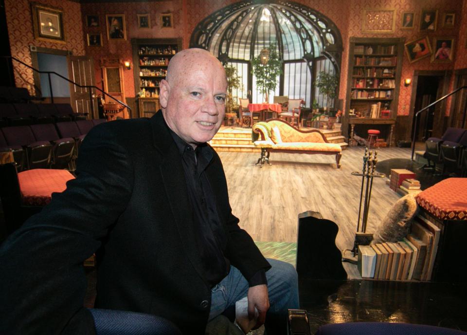 Hartland playwright David MacGregor sits in front of the set on Friday, April 29, 2022 for his original play, "Sherlock Holmes and the Adventure of the Ghost Machine" at the Purple Rose Theatre Company in Chelsea.