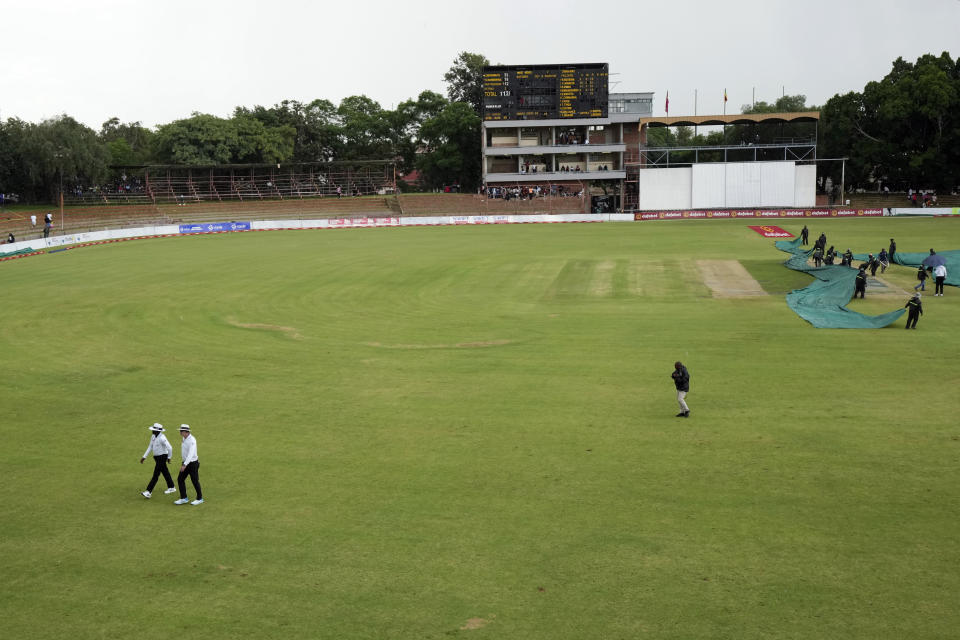 Umpires walk off the pitch following rains on the first day of the Test cricket match between Zimbabwe and West Indies at Queens Sports Club in Bulawayo, Zimbabwe, Saturday,Feb, 4, 2023. (AP Photo/Tsvangirayi Mukwazhi)