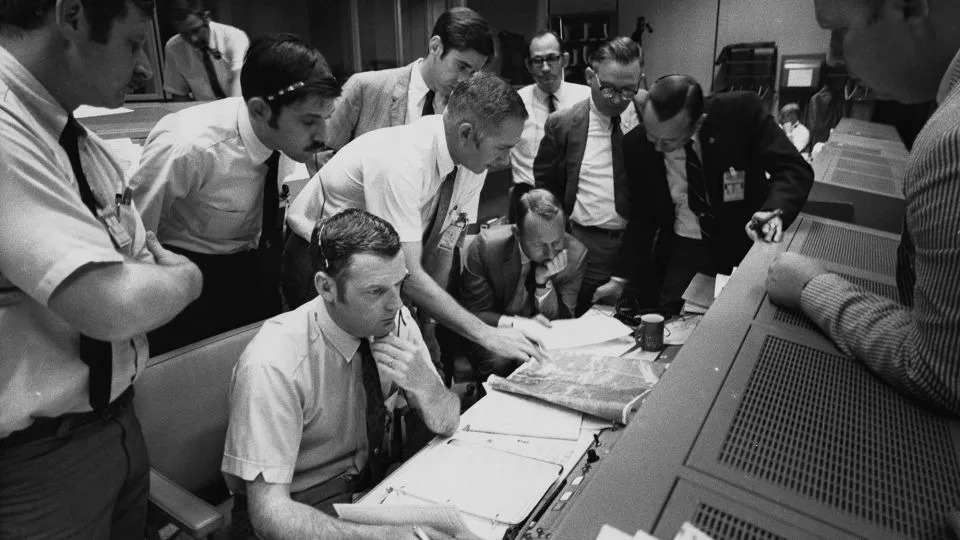 Flight controllers gather around NASA Flight Director Glynn Lunney (seated, foreground) in the control room at what's now called Johnson Space Center in Houston during the Apollo 13 aborted lunar landing mission, on April 15, 1970. - Space Frontiers/Archive Photos/Getty Images