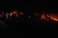 A journalist, left, records lava from the Mauna Loa volcano as it erupts Wednesday, Nov. 30, 2022, near Hilo, Hawaii. (AP Photo/Gregory Bull)