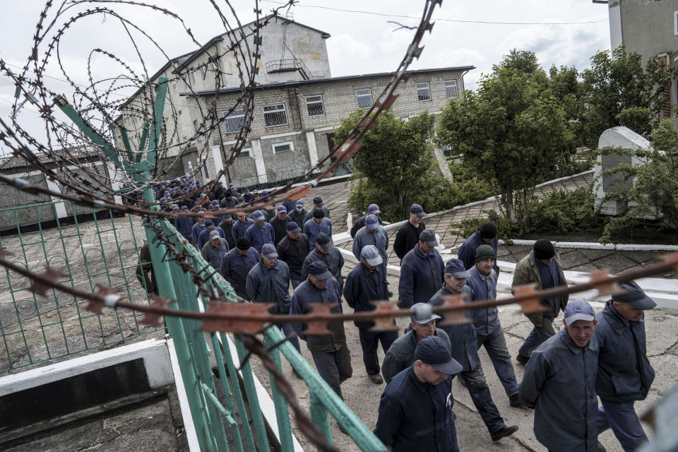 Captured Russian soldiers walk to shelters during an air raid alarm at the prisoner of war detention center in Ukraine's Lviv region, Thursday, April 25, 2024. AP visited the center as part of a small group of journalists on the condition that its exact location be withheld. (AP Photo/Evgeniy Maloletka)