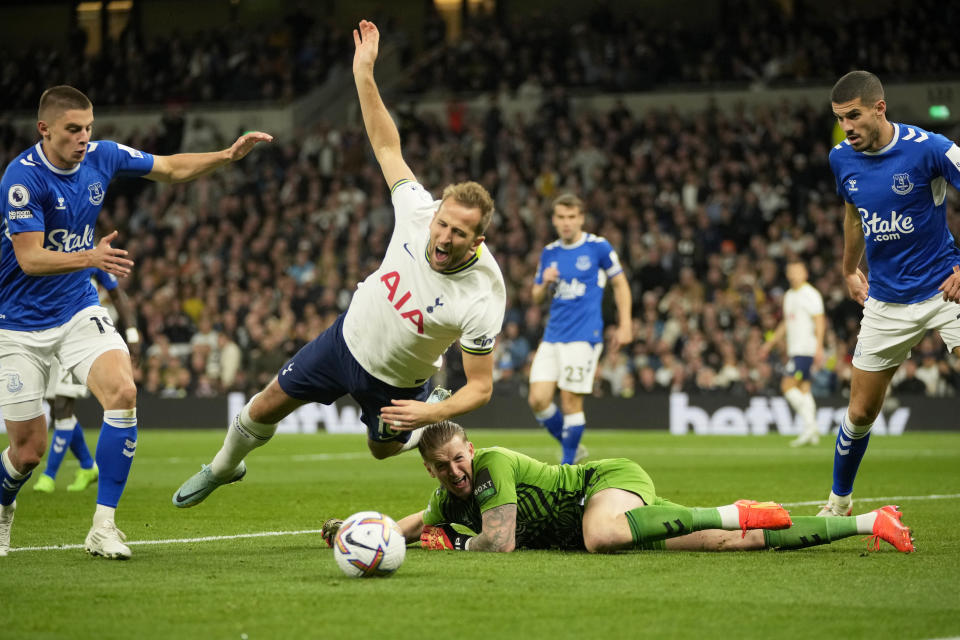 Everton's goalkeeper Jordan Pickford dives for a save but ends up bringing down Tottenham's Harry Kane, center, and giving away a penalty during the English Premier League soccer match between Tottenham Hotspur and Everton at the Tottenham Hotspur Stadium in London, England, Saturday, Oct. 15, 2022. (AP Photo/Kin Cheung)
