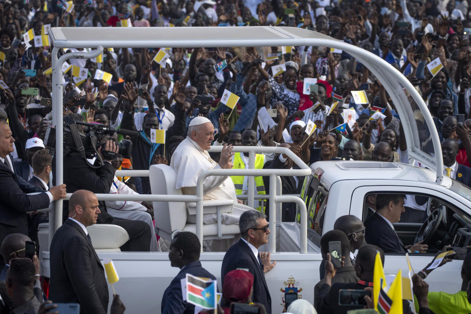 Pope Francis, center, waves as he tours the audience in his vehicle after arriving for a Holy Mass at the John Garang Mausoleum in Juba, South Sudan Sunday, Feb. 5, 2023. Pope Francis is in South Sudan on the final day of a six-day trip that started in Congo, hoping to bring comfort and encouragement to two countries that have been riven by poverty, conflicts and what he calls a "colonialist mentality" that has exploited Africa for centuries. (AP Photo/Ben Curtis)