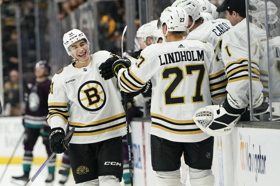 Boston Bruins center Matthew Poitras, left, celebrates his goal with the bench during the third period of an NHL hockey game against the Anaheim Ducks Sunday, Oct. 22, 2023, in Anaheim, Calif. (AP Photo/Ryan Sun)