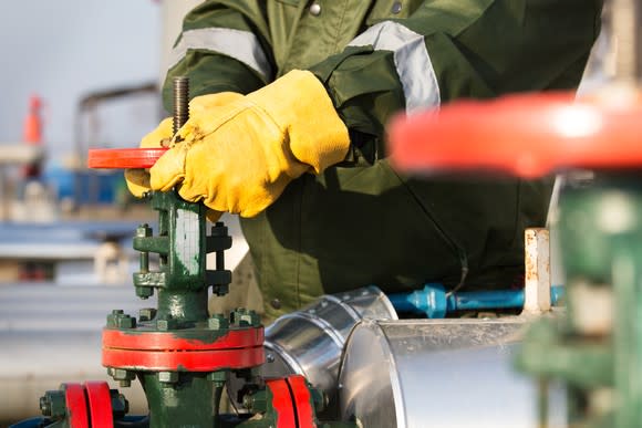 A worker turning a valve.