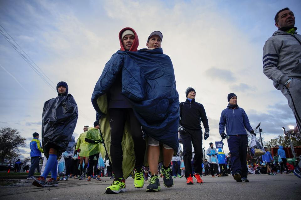 Runners cover themselves from the low temperatures and strong wind before the start of the New York City Marathon in New York, November 2, 2014. . REUTERS/Eduardo Munoz (UNITED STATES - Tags: SPORT ATHLETICS TPX IMAGES OF THE DAY)