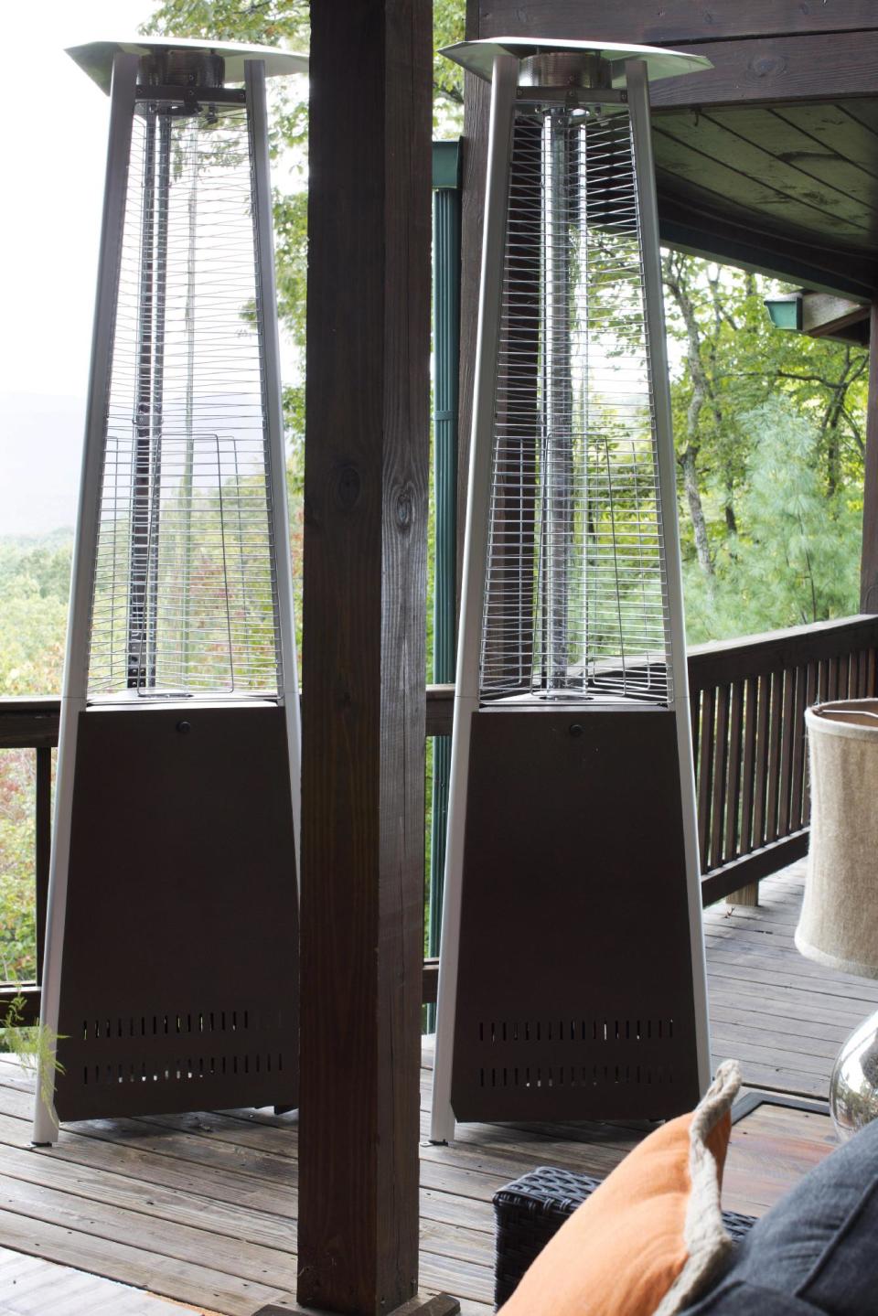 In this undated photo provided by Brian Patrick Flynn and Hayneedle.com, the designer Flynn keeps sculptural outdoor heaters standing by his covered outdoor living and dining spaces. Should the weather become cold, these easily wheel back and, bringing the proper amount of heat wherever it's needed. Once lit with enclosed propane tanks, not only do the heaters keep guests warm, but the heaters themselves also take on an artistic presence, adding to Flynn's decor of the space. (AP Photo/Brian Patrick Flynn, Hayneedle.com)