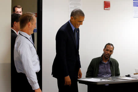 U.S. President Barack Obama smiles with poll workers as he arrives to cast his vote for president in early voting at the Cook County Office Building in Chicago, Illinois, U.S. October 7, 2016. REUTERS/Jonathan Ernst