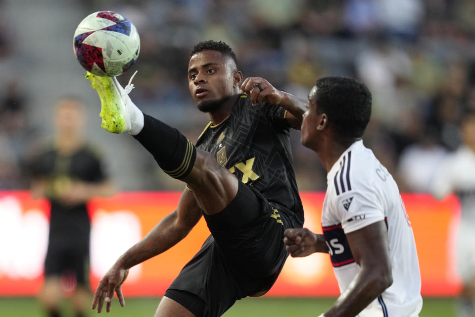 Los Angeles FC defender Diego Palacios, left, controls the ball against Vancouver Whitecaps defender Karifa Yao during the first half of an MLS soccer match in Los Angeles, Saturday, June 24, 2023. (AP Photo/Ashley Landis)