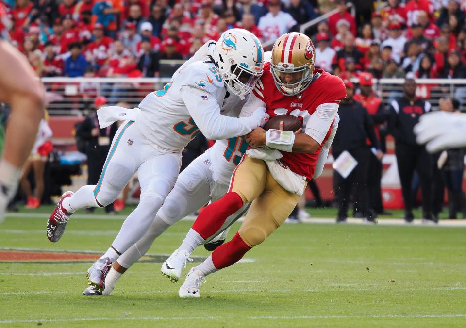 San Francisco 49ers quarterback Jimmy Garoppolo (10) is sacked by Miami Dolphins inside linebacker Jerome Baker (55) and offensive linebacker Jaelan Phillips (15) during the first quarter at Levi's Stadium.