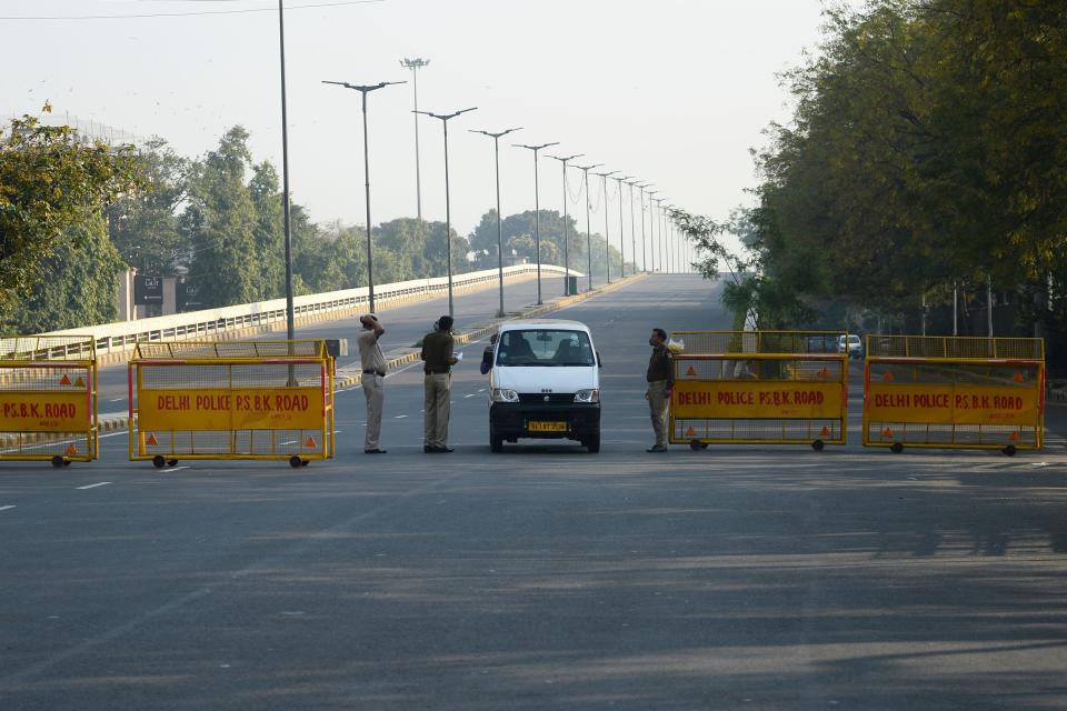 Police personnel speaks to a car driver on a deserted road during a one-day Janata (civil) curfew imposed amid concerns over the spread of the COVID-19 novel coronavirus, in New Delhi on March 22, 2020. (Photo by Sajjad HUSSAIN / AFP) (Photo by SAJJAD HUSSAIN/AFP via Getty Images)