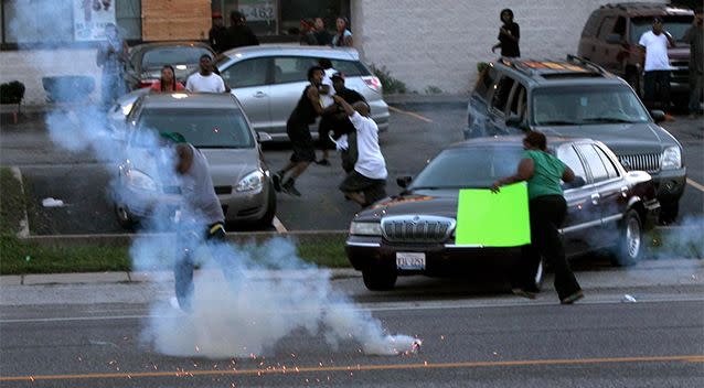 People scatter as police officers fire tear gas in Ferguson, Missouri. Photo: AP.