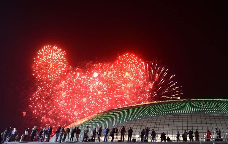 People watch the fireworks exploding over the Russian Black Sea resort of Sochi, on February 7, 2013, to celebrate the one year countdown to the Sochi 2014 Winter Olympics opening. A year before athletes converge on Sochi for the Winter Olympics, the Russian seaside city remains a vast construction site, with traffic choking the streets and locals bracing for another year of nonstop work