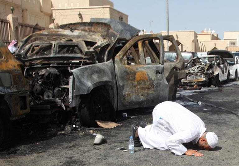 The cousin of a victim prays at the site of a suicide bombing that targeted the Shiite Al-Anoud mosque in the Saudi coastal city of Dammam on May 29, 2015