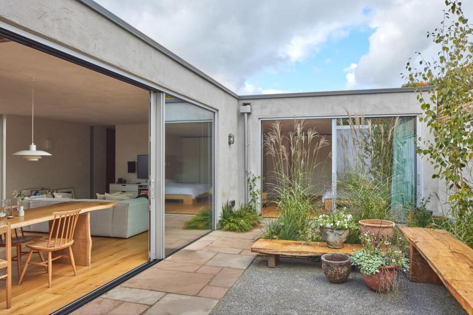 Glass doors roll back to open the house to the courtyard garden (Juliet Murphy)