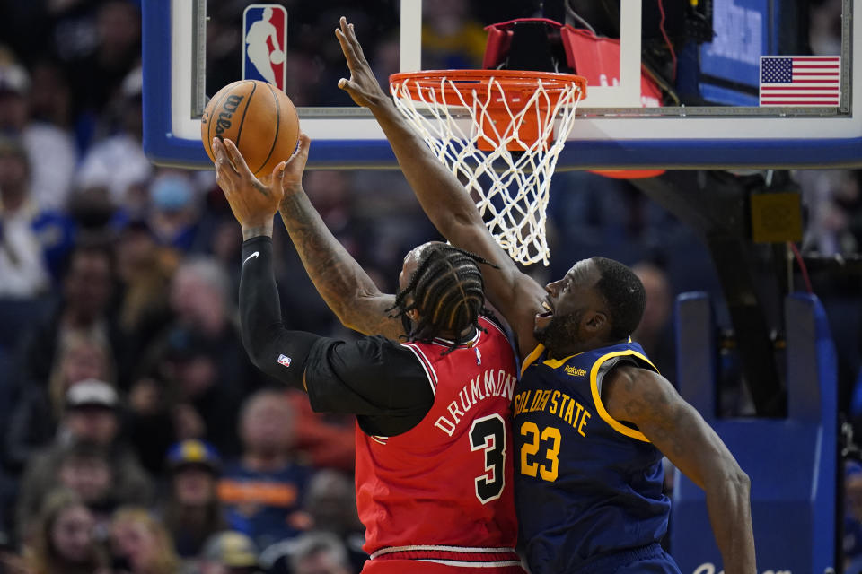 Chicago Bulls center Andre Drummond (3) tries to shoot while defended by Golden State Warriors forward Draymond Green (23) during the first half of an NBA basketball game in San Francisco, Friday, Dec. 2, 2022. (AP Photo/Godofredo A. Vásquez)