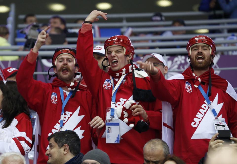 Fans of Team Canada cheer as they wait for the start of the men's preliminary round ice hockey game against Finland at the 2014 Sochi Winter Olympics, February 16, 2014. REUTERS/Jim Young (RUSSIA - Tags: OLYMPICS SPORT ICE HOCKEY)