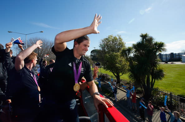 Gold medalist Nathan Cohen waves to school children as they travel by bus to the New Zealand Olympic homecoming ceremony at Pioneer Stadium on August 24, 2012 in Christchurch, New Zealand. (Photo by Sandra Mu/Getty Images)