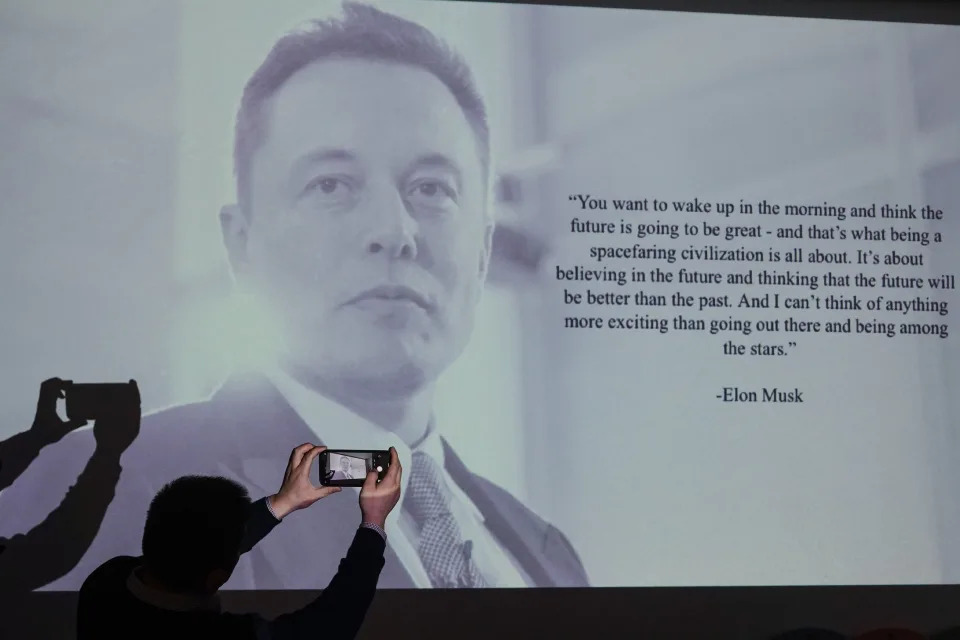 SHANGHAI, CHINA - JANUARY 18: People take photos of a portrait of Tesla Inc CEO Elon Musk at a Tesla showroom on January 18, 2021 in Shanghai, China. (Photo by VCG/VCG via Getty Images)